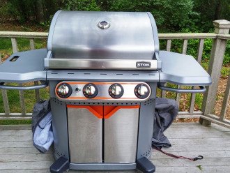 propane gas grill with cover is kept on lower deck.