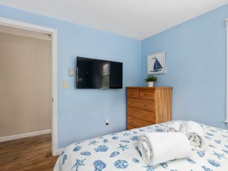 1st floor bedroom with queen bed and wall mounted smart TV